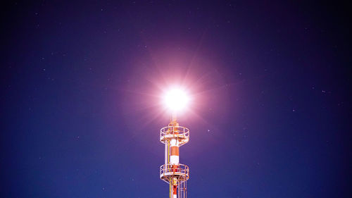 Low angle view of illuminated tower against blue sky