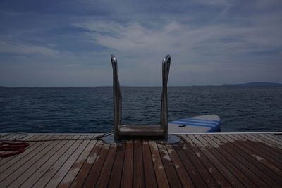 Wooden pier on sea against sky