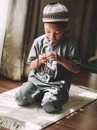 Full length of a boy sitting on floor at home