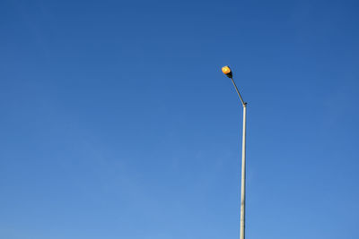 Low angle view of street light against clear blue sky