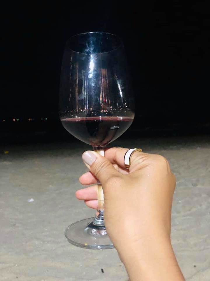 alcohol, wine, holding, hand, glass, drink, one person, refreshment, human hand, human body part, wineglass, food and drink, red wine, real people, women, lifestyles, leisure activity, unrecognizable person, close-up, body part, finger, black background, drinking