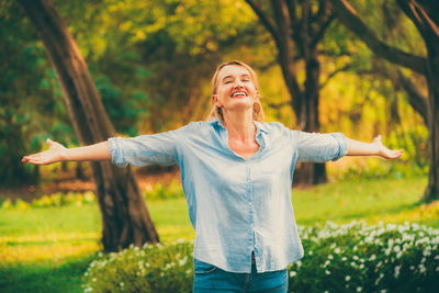 Woman with arms outstretched standing on field