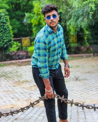 Portrait of young man wearing sunglasses standing outdoors