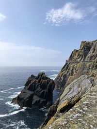 Rock formations by sea against sky