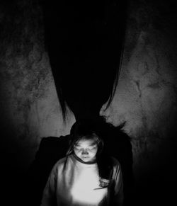 Beautiful young woman standing against wall