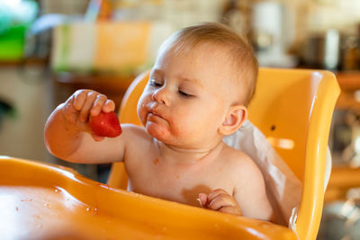 Cute baby girl eating fruit