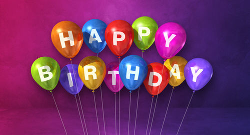 Close-up of multi colored balloons against blue background