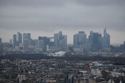 Aerial view of buildings in city against sky