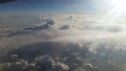 Sun shining in sky above clouds