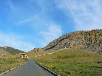 Road by mountain against sky