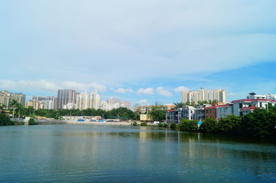 Buildings by sea against sky