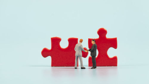 Close-up of two people standing against white background