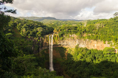 Scenic view of waterfall against sky