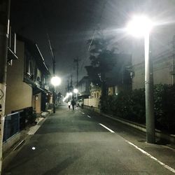 Street amidst illuminated buildings in city at night