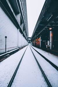 Railroad tracks against sky during winter