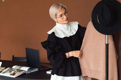 Fashion woman in vintage black and white dress standing in modern work place 