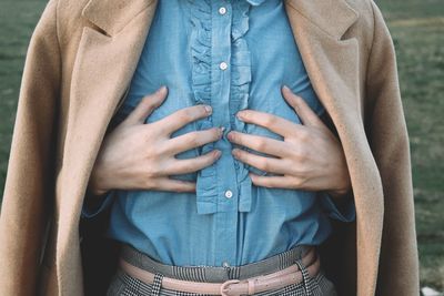 Midsection of woman hands on chest