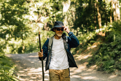Portrait of young man standing in forest