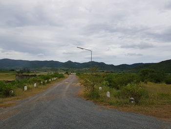 Road amidst green landscape against sky