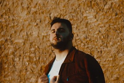 Young man standing against wall