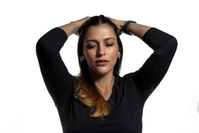 Portrait of young woman standing against white background