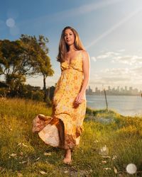 Young woman smiling while standing on land against sky