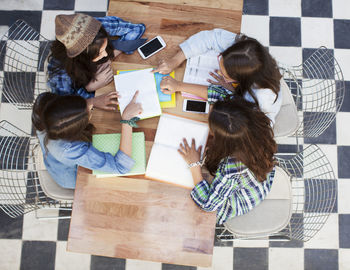 High angle view of girl sitting on table