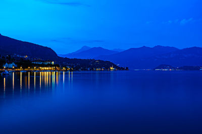 Scenic view of lake and mountains against blue sky