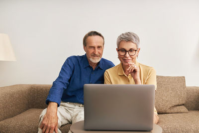 Senior couple talking on video call while looking at laptop