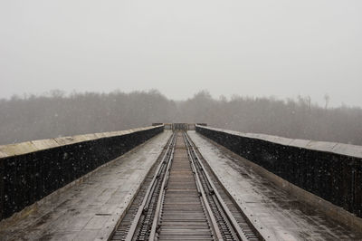 Railroad tracks against clear sky during winter