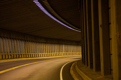 Empty road in illuminated tunnel