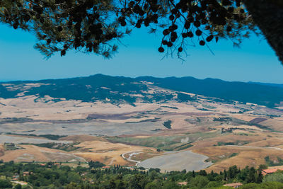 Aerial view of landscape and mountains against blue sky