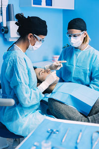 Dentists operating patient in medical clinic