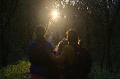 Rear view of friends standing in forest