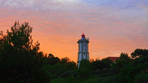 Lighthouse against sky during sunset