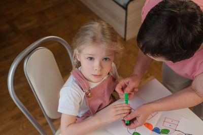 High angle portrait of girl drawing on paper