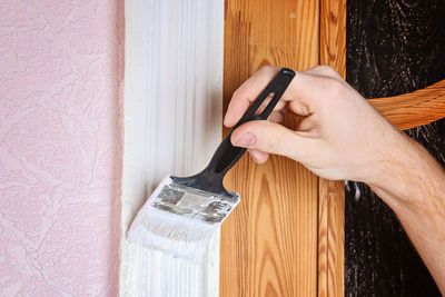 Close-up of hand painting wooden door