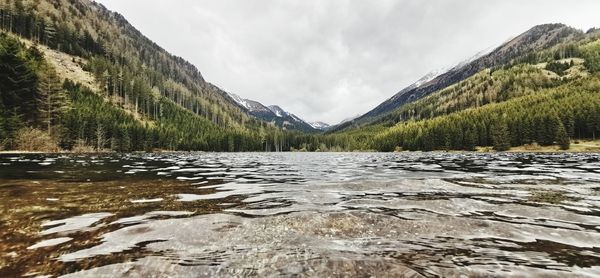 Scenic view of lake by mountains against sky