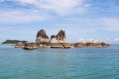 Rock formations in sea against sky