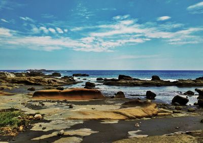 Rocks on beach against sky