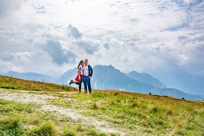 Woman and man on mountain against sky