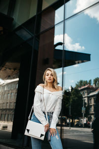 Young woman standing against building in city