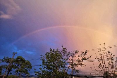 Low angle view of rainbow against sky at sunset