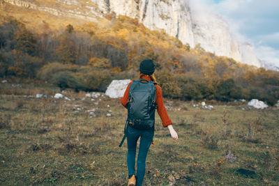 Rear view of man walking on rock