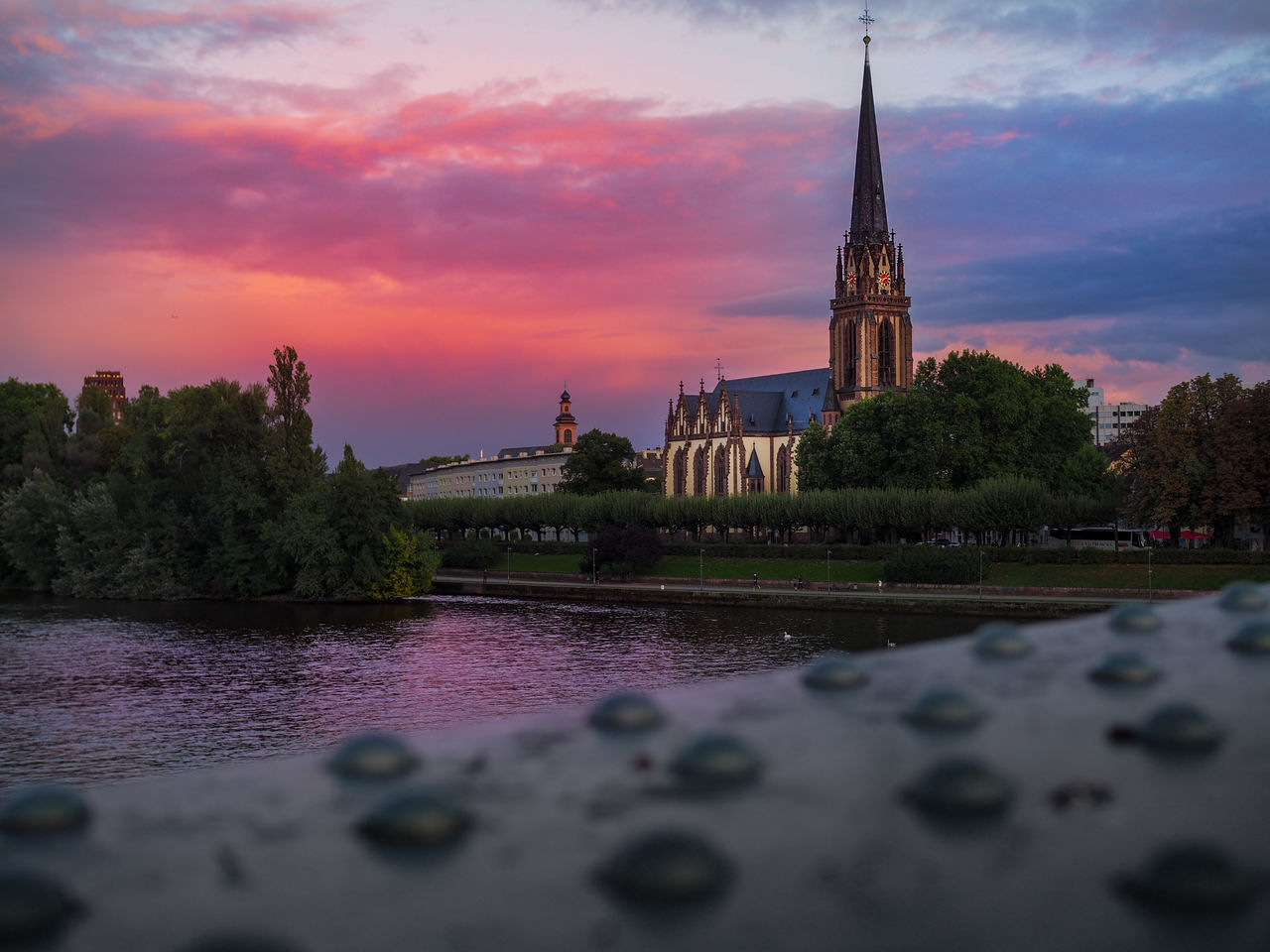 VIEW OF BUILDING BY RIVER AGAINST SKY