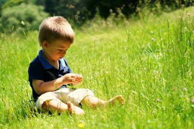 Boy sitting on field