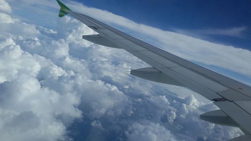 Cropped image of airplane flying over clouds