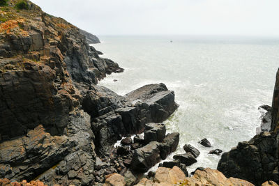 Photo of some weathered eroded cracked rocks on the coastline