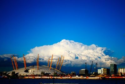 Smoke emitting from factory against blue sky