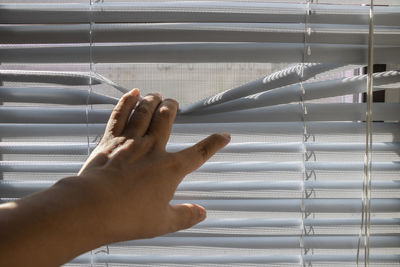 Close-up of human hand against metal wall